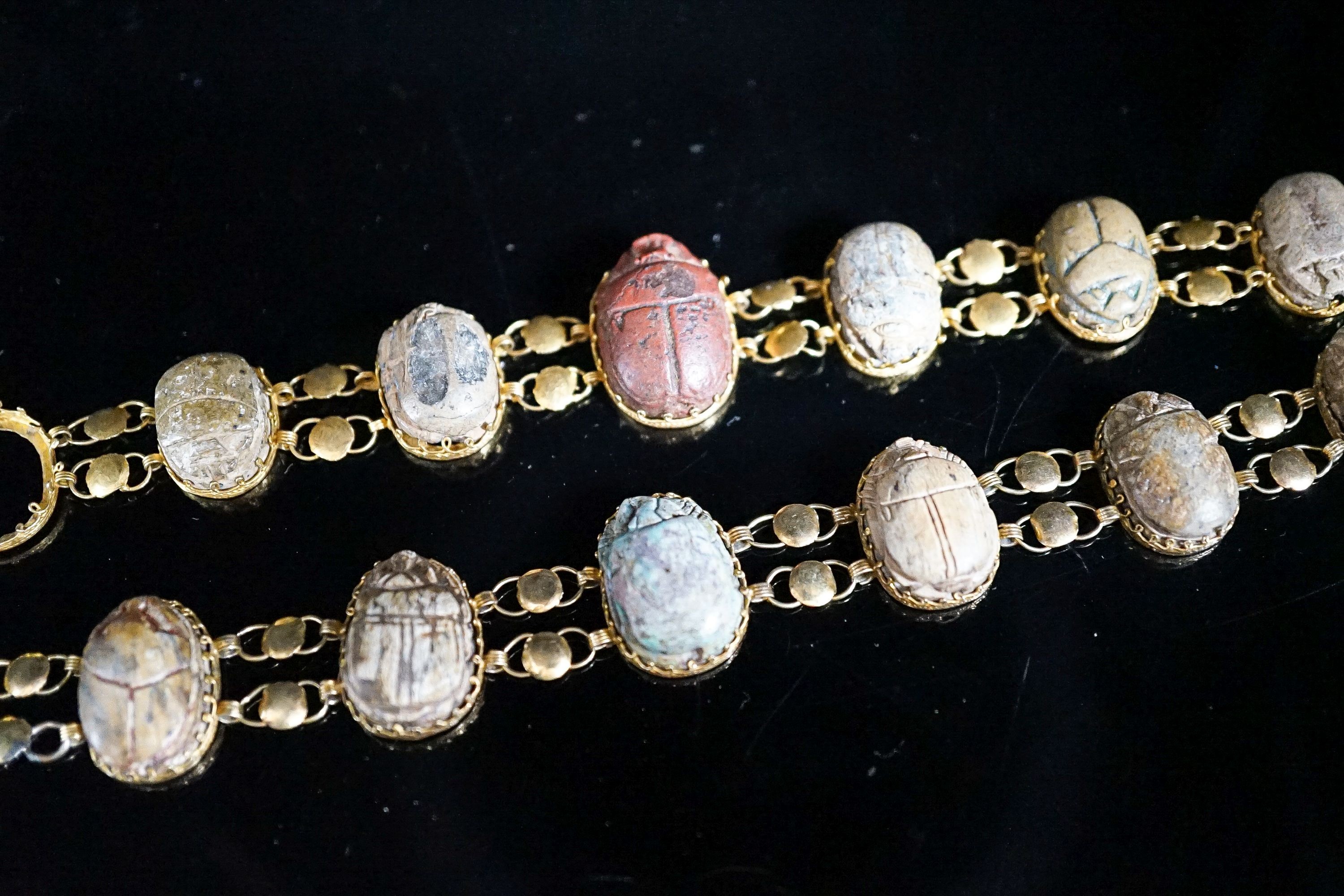 Two similar early 20th century yellow metal mounted scarab bracelets (a.f.), 18.5cm et infra, gross weight 38.1 grams.